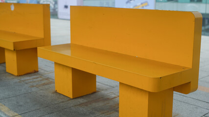 yellow painted metal benches on the street