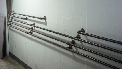 Metal pipe railing on cement wall inside old building