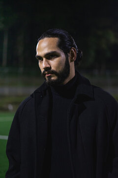 retrato de hombre de parpados caidos con mirada intimidante vestido de negro