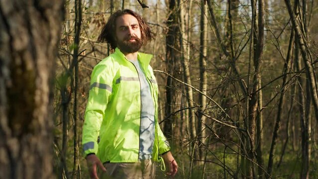 Rescue squad leader guiding route through the woods to collect evidence during searching operation to locate missing person. Shouting individual's name, civil disappeared in a forest. Camera A.