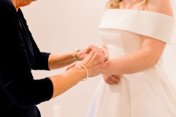 Obraz na płótnie Canvas A bride's mother is putting on a bracelet on her wrist.