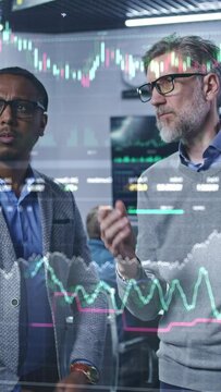 Multiracial financial analysts look on computer generated virtual 3D real-time stocks on glass wall, analyze business strategy in investment bank. Computers and big digital screens on background