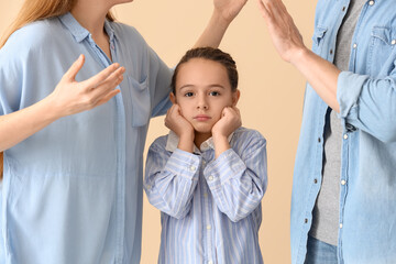 Sad little girl and her arguing parents on beige background. Divorce concept