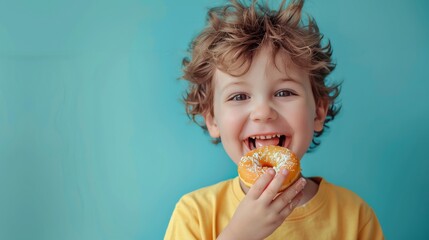 The image shows a happy boy eating a donut. - obrazy, fototapety, plakaty