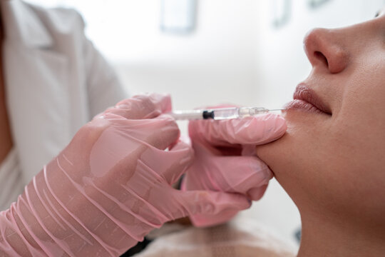 Close up of Beautiful woman Mouth and Lips: Female Doctor Injecting Botox for Lip Rejuvenation Skincare Treatment