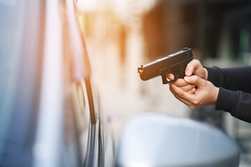 Thieves are using guns to rob a car, threatening a woman with car keys. - obrazy, fototapety, plakaty