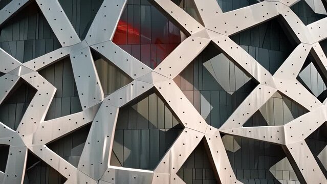 A maze of overlapping geometric shapes make up the faÃ§ade of this stadium giving it a sense of depth and dimension.