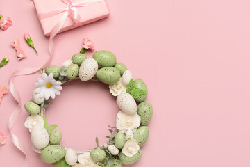 Easter wreath with flowers, eggs and butterflies on pink background