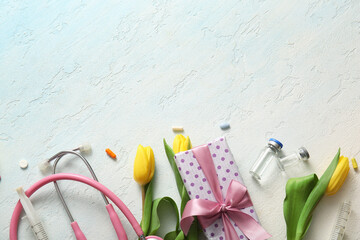 Stethoscope with yellow tulips, gift box and ampules for International Nurses Day on light blue...