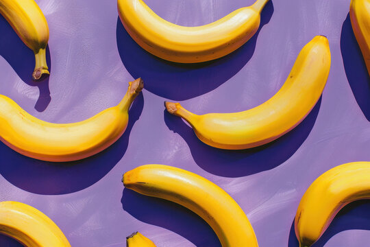 Pattern of bananas on purple and yellow background with tops facing viewer