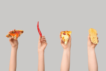 Many hands holding pizza slices, chili and cheese on white background