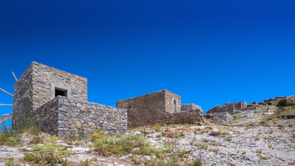 Ruin of old windmills on the hilltop (Lasithi Plateau, Crete, Greece) - obrazy, fototapety, plakaty
