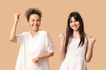 Happy mature woman with her teenage daughter on brown background. Mother's day