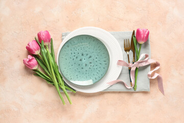 Table setting with tulips on beige background. Mother's day concept