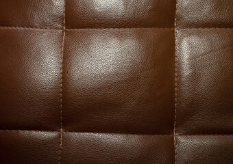 The surface of the brown leather sheet has stitches.