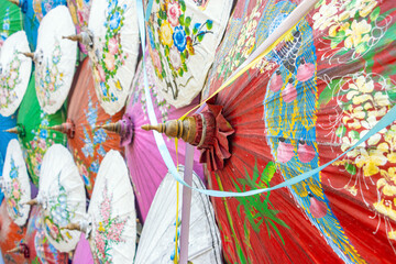 A wall of traditional umbrellas decorated with a painting
