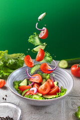 Healthy fitness fresh simple salad levitation. Photo of healthy food Vegetable green salad...