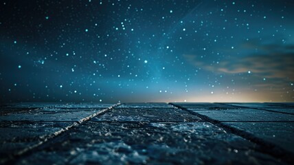 A dark blue night sky full of stars with a cobblestone street in the foreground.
