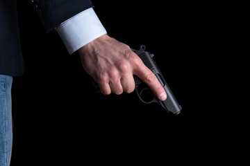 A man in handcuffs holds a gun in his hand