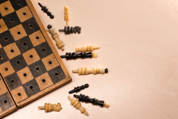 Vintage road bone chess pieces scattered beside non-magnetic board.
