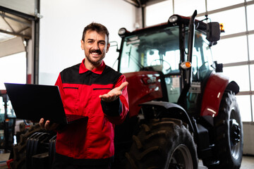 Professional serviceman holding diagnostic tool and repairing tractor.