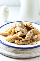 Penne Pasta baked with Meat on bright wooden Background. Close up