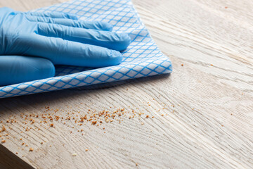 Cleaning wiping wood countertop worktop with a disposable cloth. Housework chores concept