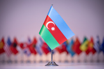 Electric blue flag of Azerbaijan among row of other flags, under sky