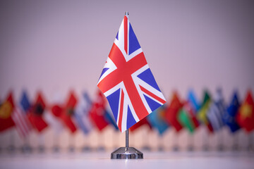 A small British flag stands among a row of various flags