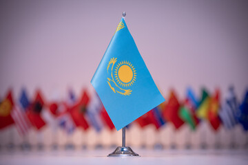 a small flag of kazakhstan is sitting in front of a row of other flags