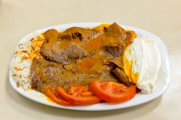 Turkish and Arabic Traditional Ramadan doner kebab with tasty tomato sauce and rice or turkish...