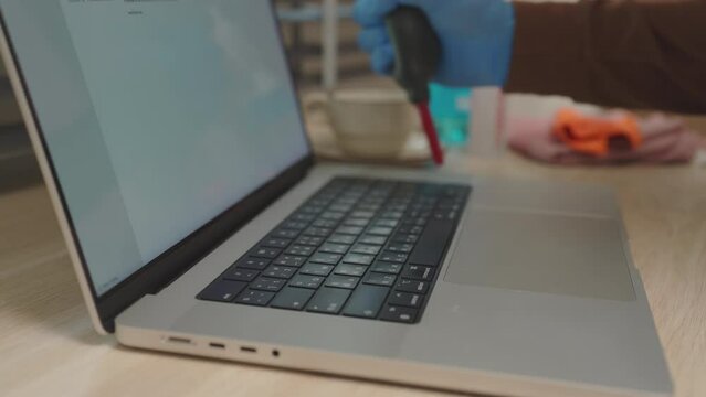 A person is using a compressed air canister to clean a laptop keyboard. Concept of urgency and the importance of keeping electronic devices clean and well-maintained