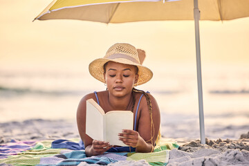 Sunset, relax or black woman reading book at ocean for alone time, rest break or holiday vacation. Beach, travel or African person with fiction story or novel for knowledge, peace or hobby in Greece
