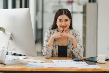 Confident young asian business woman using laptop at modern office.