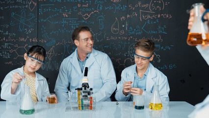 Smart teacher explain about chemical theory while student mixing colored solution or doing...