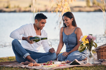 Picnic, man and woman with champagne, glass and romantic date for anniversary outdoors. Love, happy...