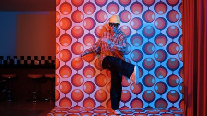 Smart break dancer wearing fancy glasses with balloon background at party stage. Happy performer...