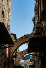 A narrow street among stone houses in old Jerusalem, Israel. - obrazy, fototapety, plakaty