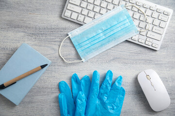Medical mask, gloves and computer keyboard on the table. - 789913079