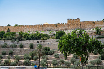 The outer walls of the old city of Jerusalem with the dome of the Al-Aqsa Mosque in the background