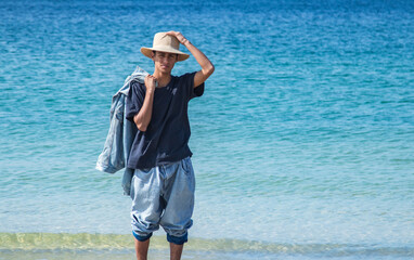 relaxed young man with hat on the beach