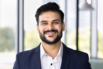 Happy successful young Indian businessman, executive, company owner in formal cloth looking at camera, smiling. Positive business professional, consultant head shot video call screen portrait