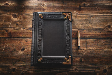 Aged black leather journal lay down to wooden table