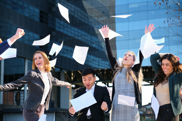 Businesspeople investors team throwing papers up in the air at street celebrating success,...