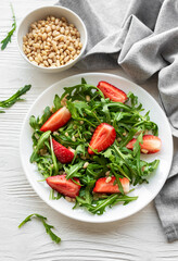 Fresh Strawberry Arugula Salad With Pine Nuts Served on a Bright Day