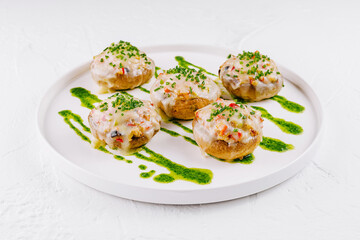 Gourmet stuffed mushrooms on plate with pesto drizzle