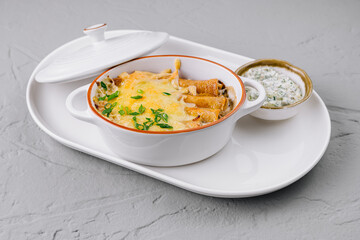 Baked cheesy pasta casserole with herbs
