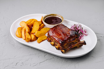 Succulent bbq pork ribs with wedges and sauce