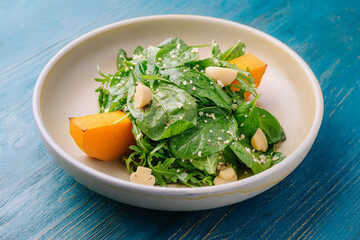 Fresh spinach and pumpkin salad on ceramic plate