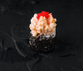 Gourmet sushi roll with caviar on black slate